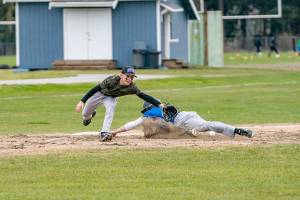 Steve Mullensky/for Peninsula Daily News
East Jefferson Rival Nathan Nisbet tags safe at third before the ball reached Quilcene’s third baseman Aiden Kate during a non-league game played in Chimacum on Monday. East Jefferson won the game 11-4.