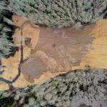 An aerial overview of the slide area shows state Highway 112 at left and a private service road at right. The state Department of Transportation reopened Highway 112 to two-way traffic, although a second slide area still requires about eight weeks of work. (State Department of Transportation)