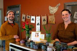 Owner John Pabst and long-term employee Stacey Sevier reminisce about years of good food and community connections at Pacific Pantry Eatery in Sequim, on the eve of the next phase of the business. Around them is the artwork by Jaiden Dokken. Emily Matthiessen/Olympic Peninsula News Group