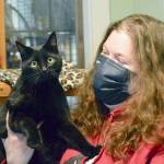 Zorro, a soon-to-be adopted resident at Center Valley Animal Rescue in Quilcene, allowed staff member Cody Maxwell to hold him while she spoke about the organizations fundraising celebration this Saturday at Port Townsends Northwest Maritime Center. (Diane Urbani de la Paz/Peninsula Daily News)