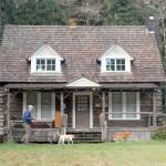 Matthew Carter of Sequim walks his dogs Roxie and Izaak, right, past the Storm King Ranger Station at Barnes Point near the shore of Lake Crescent in Olympic National Park on Saturday. The Barnes Point area is home to the Lake Crescent Lodge, which is open weekends and then daily beginning April 29, as well as the NatureBridge environmental science park and the trailhead to Marymere Falls. (Keith Thorpe/Peninsula Daily News)