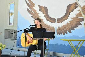 Phina Pipia of Port Townsend, pictured in spring 2021, is one of the multi-instrumentalists returning to the Buskers on the Block series of free performances this month and next. Tyler Street Plaza in downtown Port Townsend, with Nora Kingsleys wings mural, is the setting. (Diane Urbani de la Paz/Peninsula Daily News)