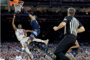 Kansas guard Ochai Agbaji (30) shoots as Villanova forward Eric Dixon defends during the second half of a college basketball game in the semifinal round of the Men's Final Four NCAA tournament, Saturday, April 2, 2022, in New Orleans. (AP Photo/Brynn Anderson)