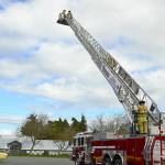 In the bucket of East Jefferson Fire Rescue's new ladder truck, firefighters Matt Sheehan, left, and Ben Richter demonstrate extension of the 95-foot ladder, along with firefighter Andy Dalrymple at the base. Diane Urbani de la Paz/Peninsula Daily News
