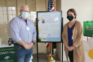 Emergency department nurse Wade Lauritzen, left, receives a DAISY award from Vickie Swanson, Olympic Medical Center's chief nursing officer.
