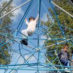 Aria Barrette, 7, top, and her sister, Alyeah Barrette, 5, both of Olympia, spend time on a jungle gym at the Dream Playground in Erickson Park in Port Angeles on Saturday. The pair were in Port Angeles visiting relatives and took an afternoon to visit the playground. (Keith Thorpe/Peninsula Daily News)