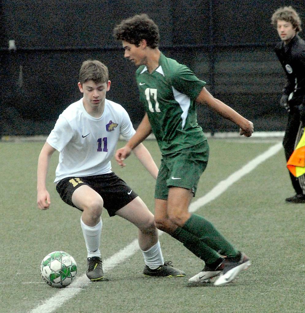 Sequims Ethan Knight, left, tries to keep the ball inbounds as Port Angeles Dayton Williams waits to take control on Tuesday at Peninsula College. (Keith Thorpe/Peninsula Daily News)