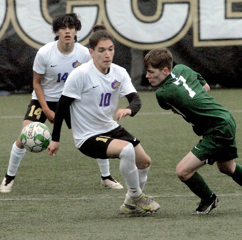 Port Angeles Kaleb Gagnon, right, tries to keep control past Sequims Rafael Flores, center, and Javier Gomez on Tuesday evening in Port Angeles. (Keith Thorpe/Peninsula Daily News)