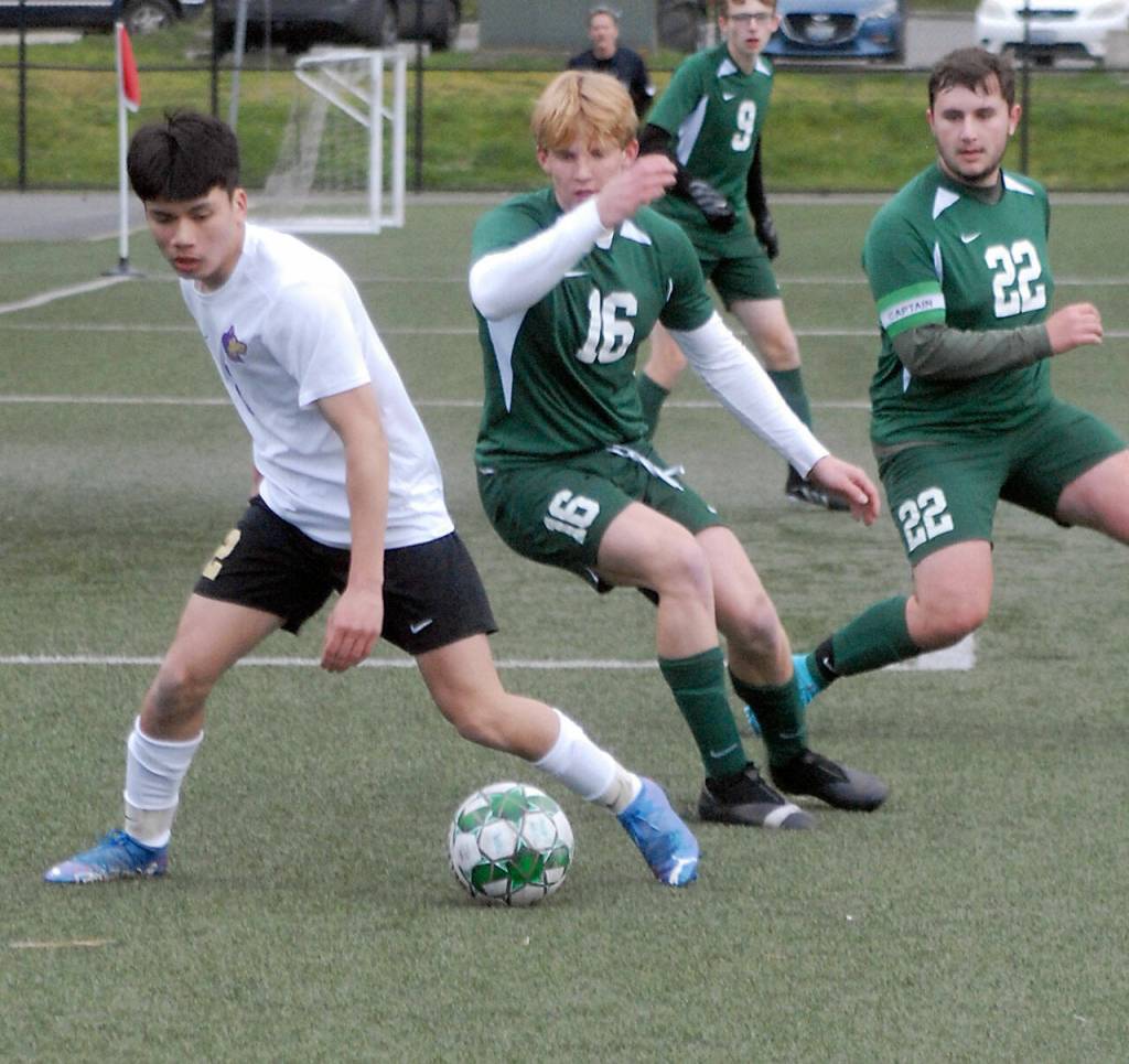 Sequims Kristian Mingoy, left, advances toward the goal as Port Angeles Zak Alton, center, and Dominick Fischer, right, defend during Tuesdays match in Port Angeles. (Keith Thorpe/Peninsula Daily News)
