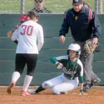 Port Angeles baserunner Peyton Rudd looks towards Kingston pitcher Jayla Moon while stealing home after a wild pitch got away from the catcher on Thursday in Port Angeles. Keith Thorpe/Peninsula Daily News
