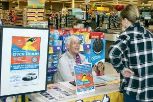 Marielle Eykeman, a volunteer, sells a Duck Derby ticket to Vonda Hartman at the downtown Safeway earlier this week. This years Duck Derby will be on the Port Angeles waterfront. (Dave Logan/for Peninsula Daily News)