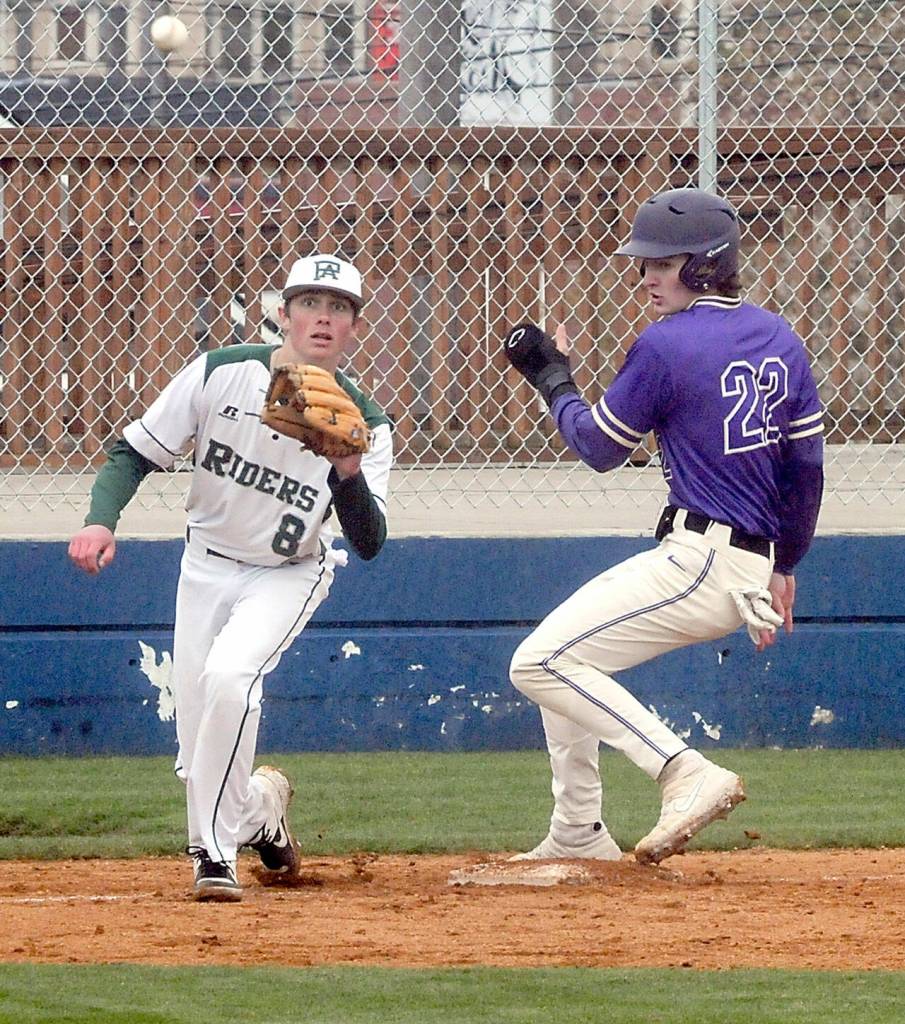 Keith Thorpe/Peninsula Daily News Port Angeles third baseman Kole Acker, left, receives the cutoff throw as North Kitsap baserunner Jaxon Gore reaches base on Wednesday in Port Angeles.
