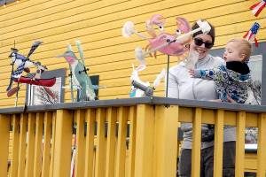 Alisha Teater of Port Angeles watches as her son, William, 14 months, who is fascinated by decorative wind spinners on display on the porch of Pacific Rim Hobby on Saturday in Port Angeles. The pair was on a family shopping excursion with a stop at the hobby store. (Keith Thorpe/Peninsula Daily News)