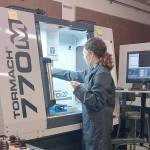 Port Townsend High School senior Haley Jones operates a computer-numeric control (CNC) milling machine, one of the pieces of equipment she learned to use in Tim Behrenfeld's computer-integrated manufacturing course.  photo by Tim Behrenfeld