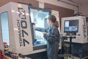 Port Townsend High School senior Haley Jones operates a computer-numeric control (CNC) milling machine, one of the pieces of equipment she learned to use in Tim Behrenfeld's computer-integrated manufacturing course.  photo by Tim Behrenfeld