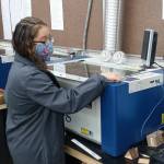 2021 graduate Cristal Gomez-Cervantes used a Zing laser printer in her computer-integrated manufacturing class at Port Townsend High School. (photo by Tim Behrenfeld)