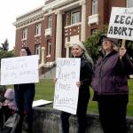 Reproductive rights supporters, from left, Tawny Bagby, Jill Coughenour and Janet Ferris, all of Port Angeles, hold signs protesting the possible overturning of the Roe v. Wade by the U.S. Supreme Court during a gathering on Tuesday in front of the Clallam County Courthouse. About 60 people took part in the event. (Keith Thorpe/Peninsula Daily News)
