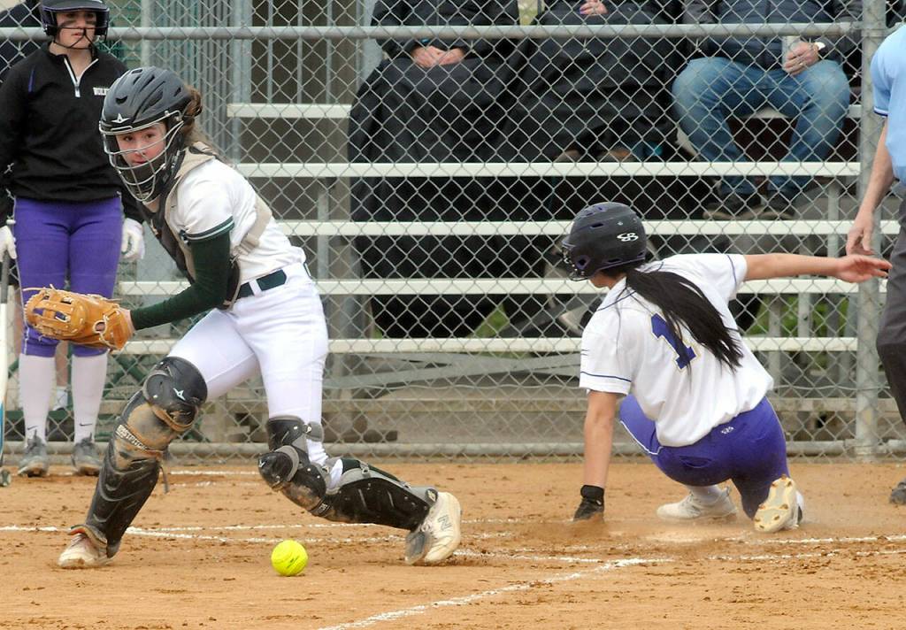 Port Angeles catcher Zoe Smithson misses an errant throw from the infield as Sequims Tayli Rome skids across the plate on Friday in Port Angeles. (Keith Thorpe/Peninsula Daily News)