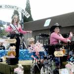 Clallam County Fair Queen Allison Pettit, front, and Queens Court Sophia Lawson ride the fairs parade float on Saturday in Sequim. Junior Royalty Kendall Adolphe rode in a separate car as an honor for designing the 2022 Irrigation Festival pin. (Keith Thorpe/Peninsula Daily News)