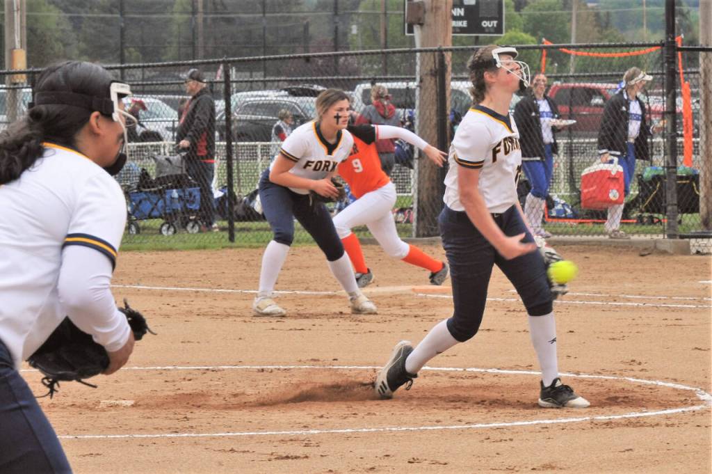 Forks Chloe Gaydeski-St. John pitches while a Rainier runner leads off first base in Centralia on Friday. At third is Elisabeth Soto and playing first base is Kaidence Rigby. Forks defeated Rainier 10-0 in five innings and eventually went on to qualify for the state 1B softball tournament. (Lonnie Archibald/for Peninsula Daily News)