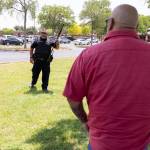 A law enforcement officer speaks with people outside Uvalde High School after shooting a was reported earlier in the day at Robb Elementary School on Tuesday in Uvalde, Texas. (William Luther/The San Antonio Express-News via AP)