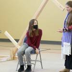Kaylee R. Klebanow, seated, playing Miranda, looks up at Brianna Palenik, playing Prospera, during rehearsals of 'The Tempest.'