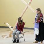 Kaylee R. Klebanow, seated, playing Miranda, looks up at Brianna Palenik, playing Prospera, during rehearsals of The Tempest.