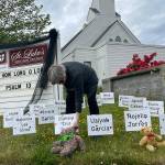 The Rev. ClayOla Gitane, rector at St. Lukes Episcopal Church, places signs and teddy bears in memory of the 21 victims of Tuesdays mass shooting at Robb Elementary School in Uvalde, Texas. (Matthew Nash/Olympic Peninsula News Group)