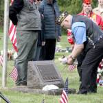 Korean War Veteran Mark Lomax lays flowers on a gravesite during a ceremony Monday at Mt. Angeles Cemetery. He represented one of several branches of the military who laid wreaths in memoriam. (Dave Logan/For Peninsula Daily News)