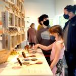 Alice Cordery, 7, a first-grade student at Jefferson Elementary School in Port Angeles, front, points to an artwork as her brother, Pat Cordery, 11, and mother, Teresa Cordery, follow along during an opening gala for Blooming Artists, an exhibition of nature-related art pieces on Tuesday at the Port Angeles Fine Arts Center. (Keith Thorpe/Peninsula Daily News)
