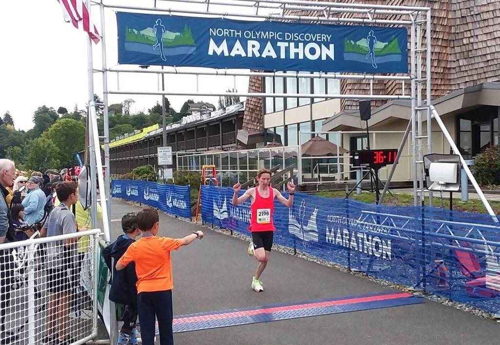 Port Angeles High School runner Langdon Larson celebrates after winning the North Olympic Discovery Marathon 10K on Saturday. (Pierre LaBossiere/Peninsula Daily News)