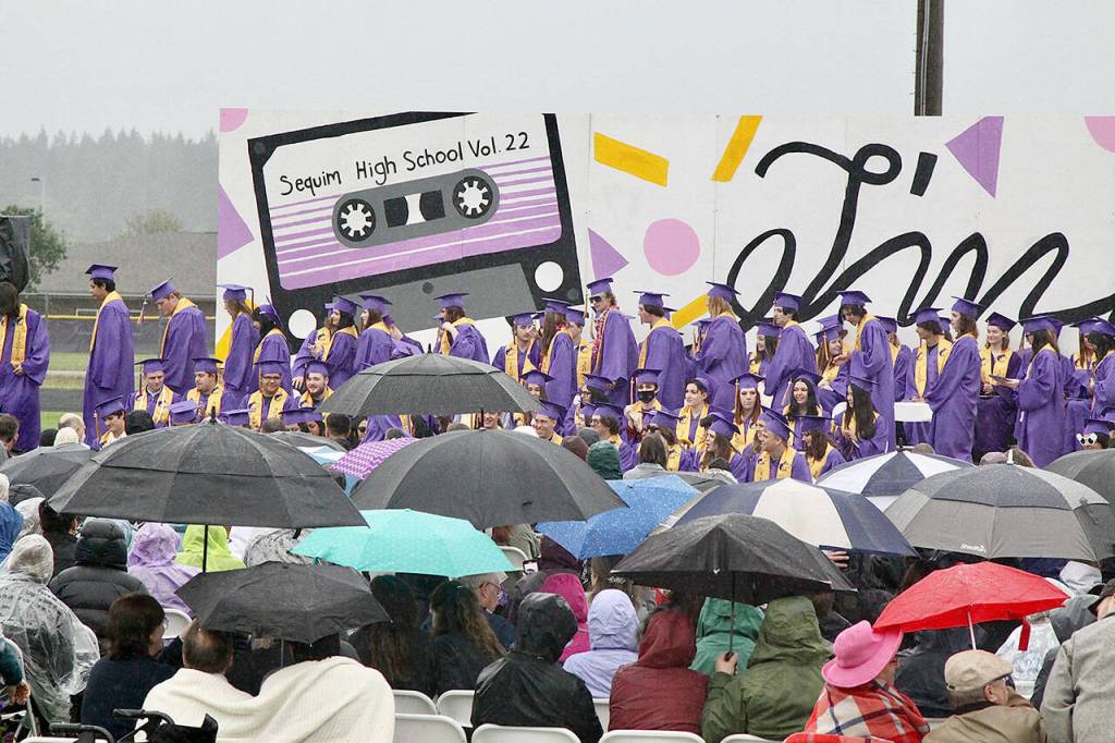 Sequim High School Principal Shawn Langston said close to 180 marched through the rain and got their diplomas Friday night outside on the schools football field. There should have been more graduating, but Langston said the circumstances around COVID-19 made it difficult for some to complete their studies on time. (Dave Logan/for Peninsula Daily News)