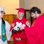 Port Townsend High Schools Duncan Kopala, right, signs the Signature Dog of Cameron Hemsiek, left, as Kenny Mustread, center, waits his turn. Eighty-two seniors received their diplomas before family and friends during the 132nd Commencement at McCurdy Pavilion on Friday night. (Steve Mullensky/for Peninsula Daily News)