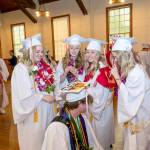 Port Townsend High Schools Sidda Hayes, Macy Smith, Charlotte Falge and Maddi Witheridge look over Tusker Behrenfelds mortar board to decipher the meaning. Eighty-two seniors received their diplomas before family and friends during the 132nd Commencement at McCurdy Pavilion on Friday night. (Steve Mullensky/for Peninsula Daily News)