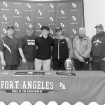 Pierre LaBossiere / Peninsula Daily News
Port Angeles football player Daniel Cable signed to play with George Fox University in Newberg, Ore., on Monday. His Roughrider coaches all attended the ceremony.