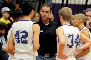 Sequim High head coach Greg Glasser, center, talks to Isaiah Moore, left, and Erik Christiansen during a timeout in the Wolves 51-46 win over North Mason in January 2020. (Olympic Peninsula News Group file photo)