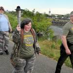 Special Olympian Deedra Hunter of Port Angeles takes a turn carrying the torch accompanied by fellow Olympian Bonny Ann Cates, left, and Chief Criminal Deputy Brian King of the Clallam County Sheriffs Office during Wednesdays Law Enforcement Torch Run along a section of the Waterfront Trail in Port Angeles. The relay, which included representatives from the sheriffs offices in Clallam and Jefferson counties, Port Angeles and Sequim police, tribal police from Lower Elwha Klallam and Jamestown SKlallam, State Patrol, Quilcene firefighters, U.S. Border Patrol, state parks personnel and Olympic National Park rangers, as well as several Special Olympians, followed a route from the west side of Port Angeles at 7 a.m. to the Hood Canal Bridge to about 5 p.m. in support of Special Olympics, which provides sports training and athletic competition for individuals with disabilities. (Keith Thorpe/Peninsula Daily News)