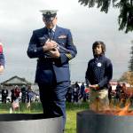 U.S. Coast Guard Chief Petty Officer Shane Thompson, accompanied by his son, Malachi Thompson, 10, a member of Junior American Citizens, carries a retiring flag for incineration on Tuesday at the Northwest Veterans Service Center in Port Angeles on Flag Day. (Keith Thorpe/Peninsula Daily News)