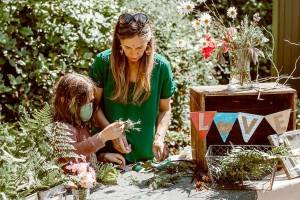 Christine Loewe, executive director of the Port Angeles Fine Arts Center, makes flower crowns with Theo Miller in this file photo. The annual celebration will be on Saturday.