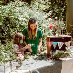 Christine Loewe, executive director of the Port Angeles Fine Arts Center, makes flower crowns with Theo Miller in this file photo. The annual celebration will be on Saturday.