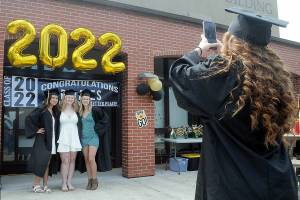Peninsula College graduate Mackenzie Hammond of Port Angeles, right, take a photograph of fellow students, from left, Myra Luong, Kyrissa Duncan and Julia Biciunas, all of Forks, prior to Saturdays commencement ceremony at the schools Port Angeles campus. About 250 students were expected to take part in the ceremony out of about 500 students eligible for degrees and certificates. (Keith Thorpe/Peninsula Daily News)