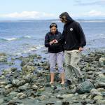 Maren Gillette and Austin Tyree, on a road trip from Wenatchee, examine a piece of beach glass they picked up on the beach at North Beach in Port Townsend on Wednesday. (Steve Mullensky/for Peninsula Daily News)