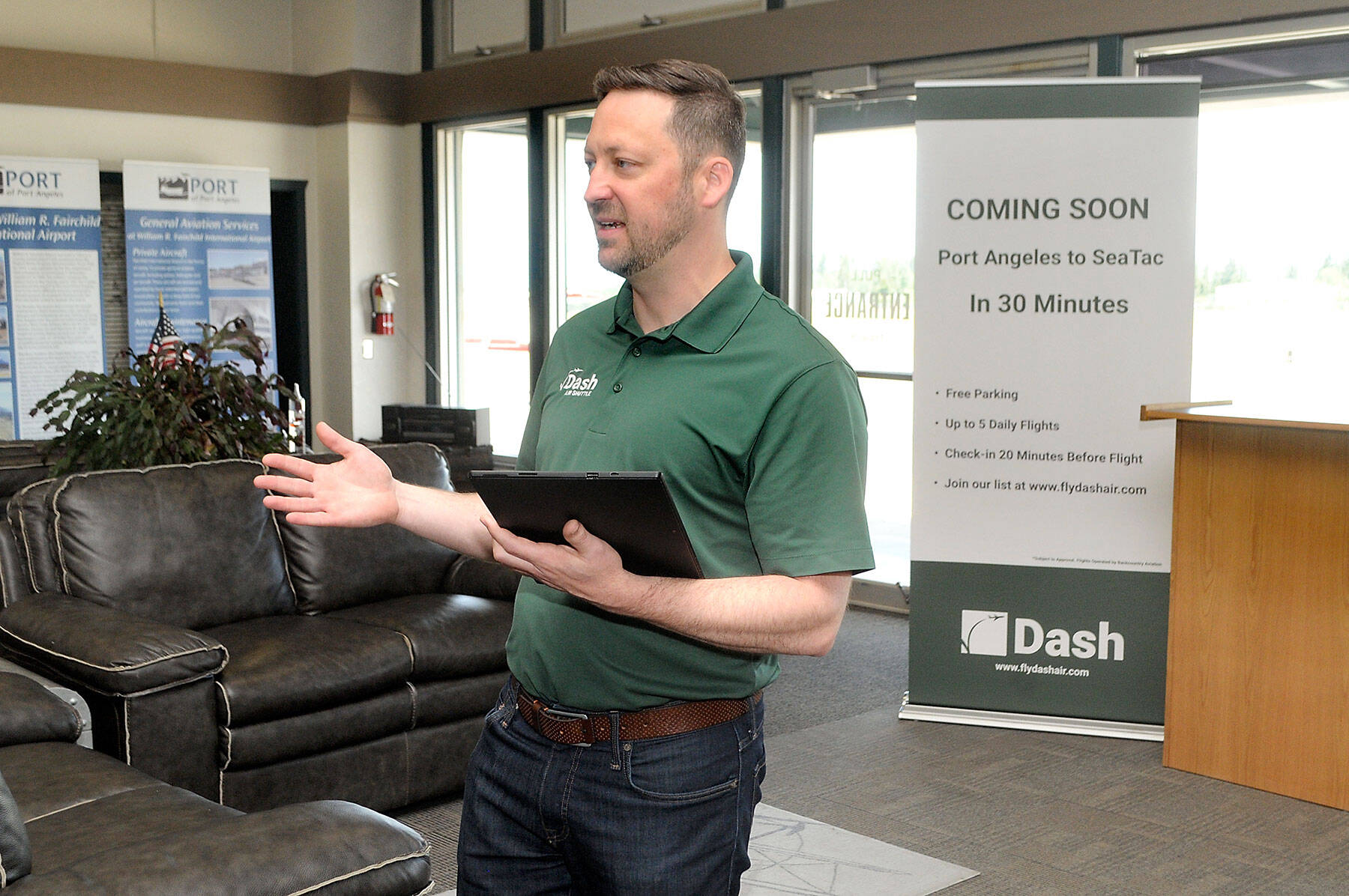 Clint Ostler, president of Dash Air Shuttle, announces details of the startup airlines plans to begin service between Port Angeles and SeaTac Airport in Seattle during a gathering of Port of Port Angeles commissioners and others on Tuesday at William R. Fairchild International Airport. (Keith Thorpe/Peninsula Daily News)