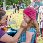 The Field Day event at Fort Worden State Park had something for everyone, including Port Townsends Rosie Dunham, 6, who is getting her face painted by artist Alexa Rose. Other activities Saturday included tug-o-war, music, bouncy houses and delicious foods. (Steve Mullensky/for Peninsula Daily News)