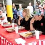 Brandon Elliott, right, of Port Angeles, ate 7 1/2 hot dogs to win a contest Monday next to the Wharf in downtown Port Angeles. Richard Wright, left, of Port Angeles finished second and K.T. Nall of Santa Barbara, Calif., placed third. (Dave Logan/for Peninsula Daily News)