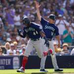 The Seattle Mariners Julio Rodriguez, left, reacts with third base coach Manny Acta after hitting a two-run home run during the fourth inning of a baseball game against the San Diego Padres on Monday in San Diego. (Gregory Bull/The Associated Press)