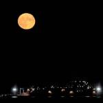 The full supermoon rises over the USNS Richard E Byrd moored at Naval Magazine Indian Island in Port Townsend Bay on Wednesday night. This is the last supermoon of the year. (Steve Mullensky/for Peninsula Daily News)