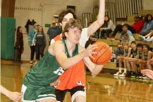 Port Angeles' Parker Nickerson muscles his way to the basket around a Central Kitsap defender during the Port Angeles summer basketball tournament Sunday. (Dave Logan/for Peninsula Daily News)