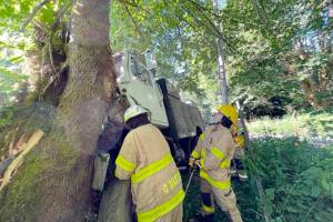 Clallam Fire District 4 firefighters remove a truck from a tree on Wednesday.