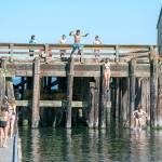 A group of youths cool off by jumping into the cove at the Marine Science Center at Fort Worden State Park on Tuesday. (Steve Mullensky/for Peninsula Daily News)